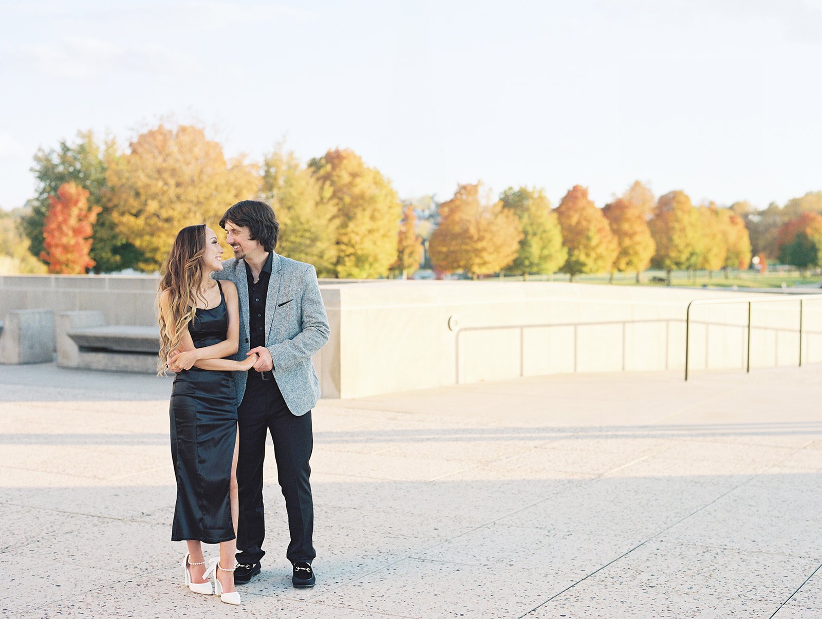 A male and female dancing at the Liberty Memorial Tower during their fall engagement session in Downtown Kansas City Missouri