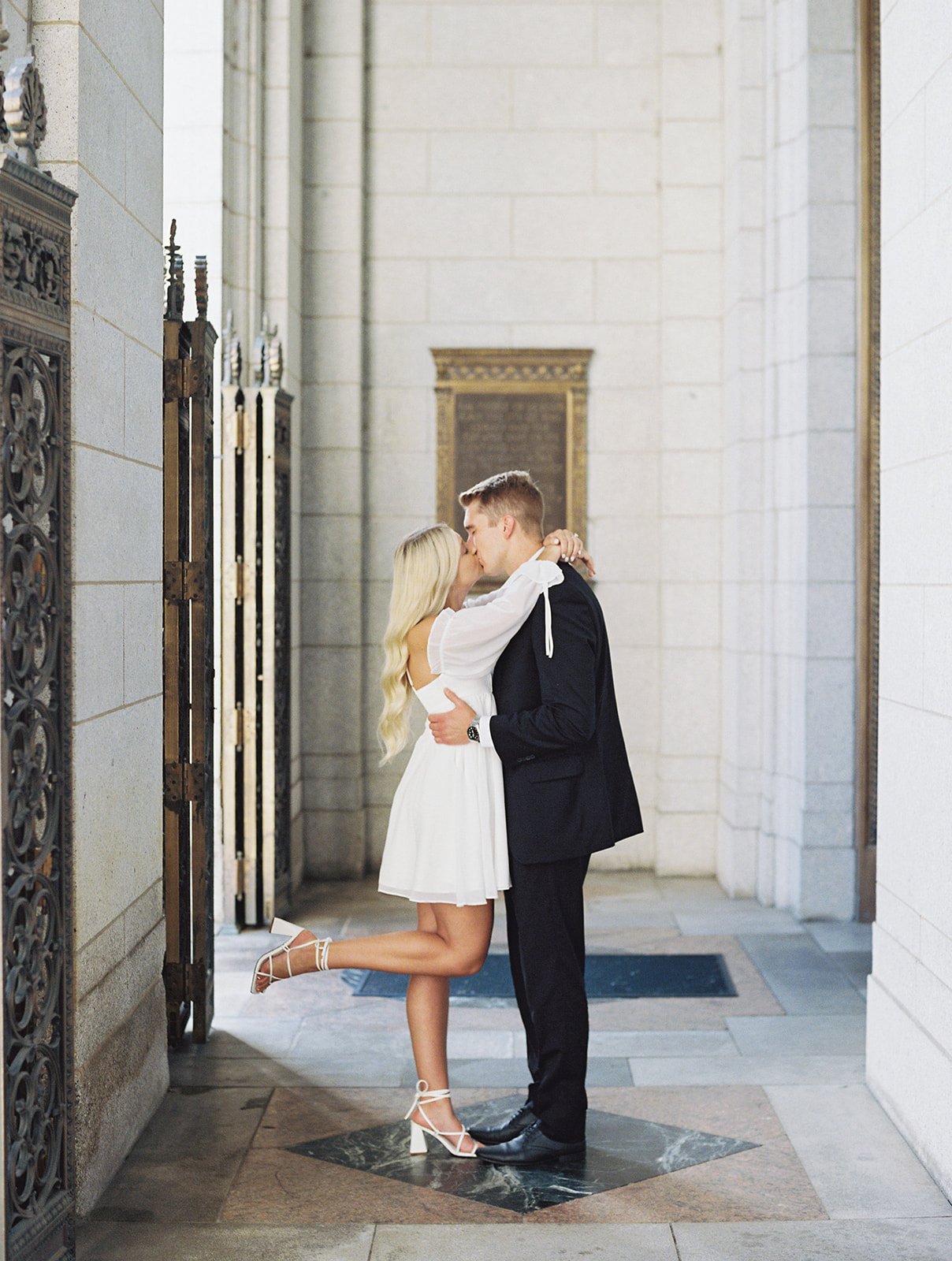 A couple facing each other sharing a kiss at the St. Louis Public Library during their engagement session.