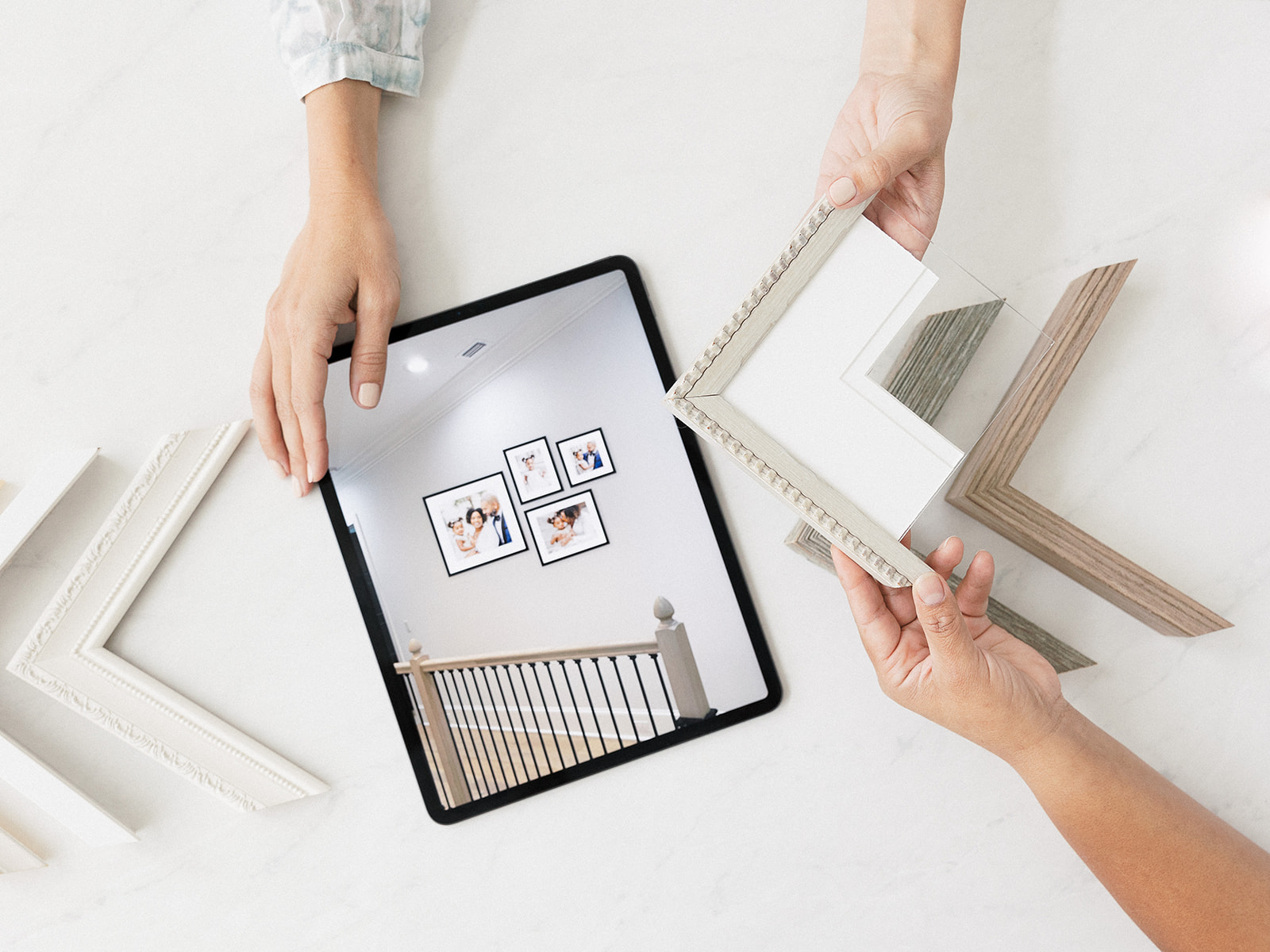 Kiley Ann Photography holding an iPad with a Gallery Wall display and custom frame corners during a reveal appointment where we design wedding artwork.