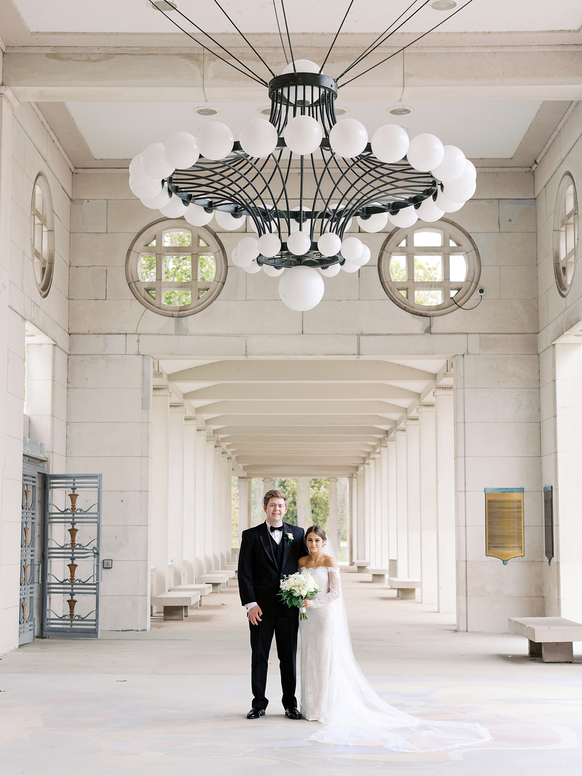 A couple standing at the Municipal Theater in St. Louis, Missouri on their wedding day in Forest Park posing for Kiley Ann Photography.