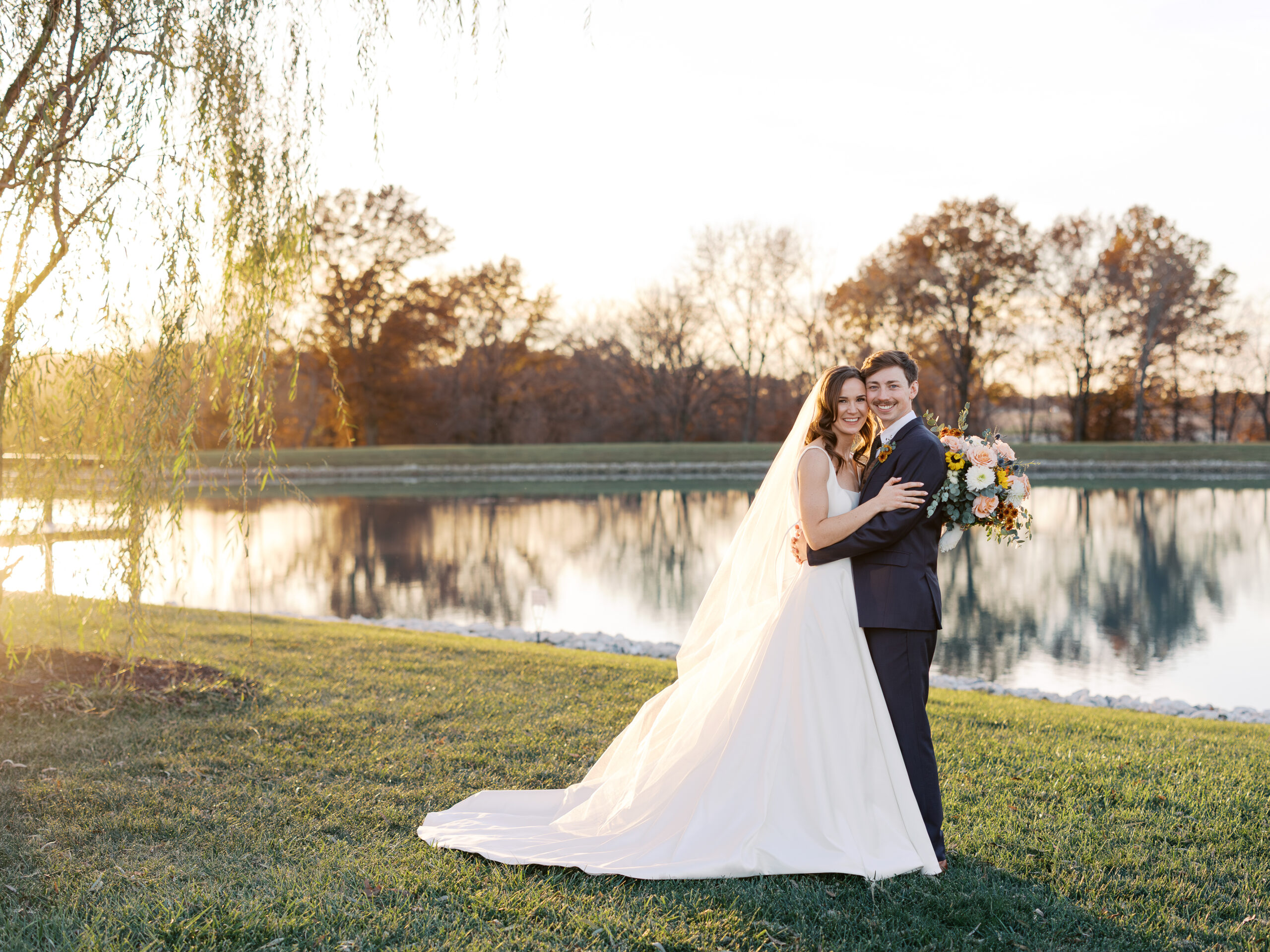 A bride and groom's November wedding portrait at Emerson Fields in Excello, Missouri captured by a Columbia Missouri photographer in front of the lake.